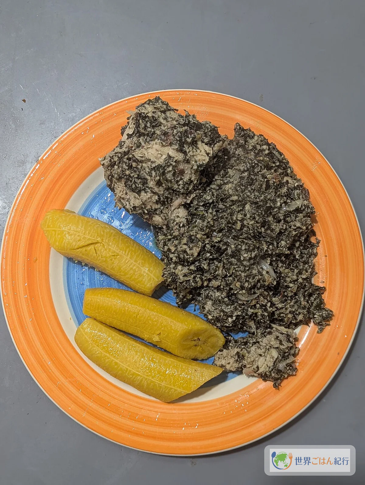 カメルーンの国民食ンドレ。ビターリーフとピーナッツの濃厚な煮込みに揚げプランテンを添えた一皿