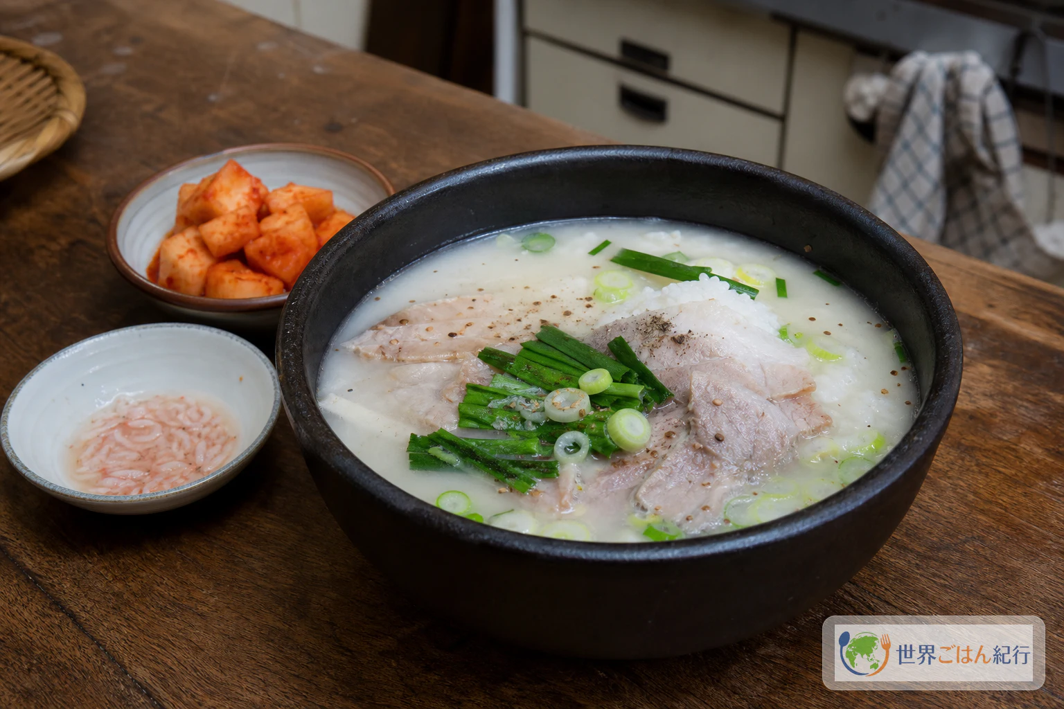 白い豚骨スープにご飯、豚肉、にら、ねぎ、새우젓を添えた韓国釜山のテジクッパ