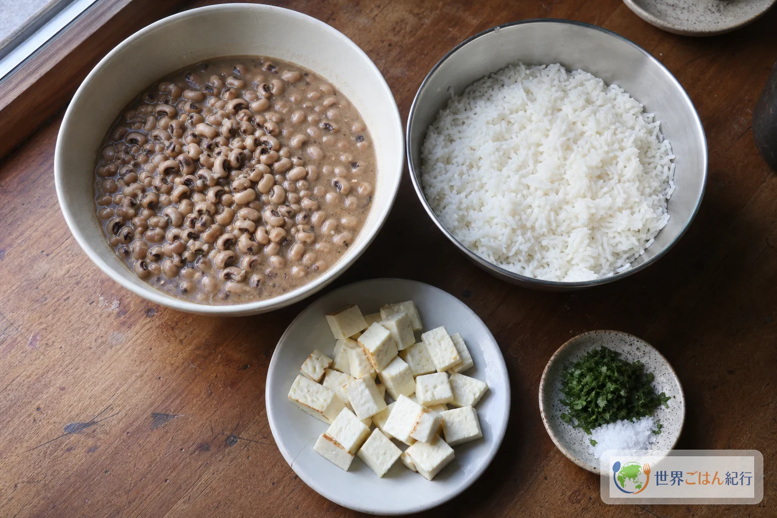 黒目豆の煮汁、米、焼く前の白いチーズを小皿に分け、塩と香味野菜を添えた材料の見取り図