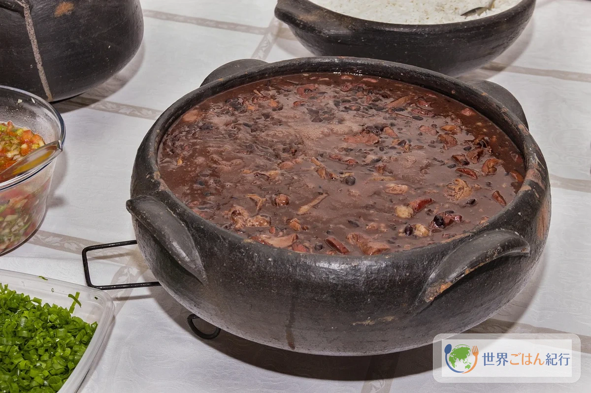 フェイジョアーダ。黒豆と豚肉の煮込みにご飯・ファロファ・オレンジを添えたブラジルの国民食