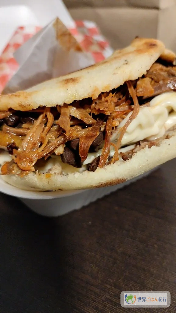 焼いたアレパを割って具材を詰めたベネズエラ式の食べ方