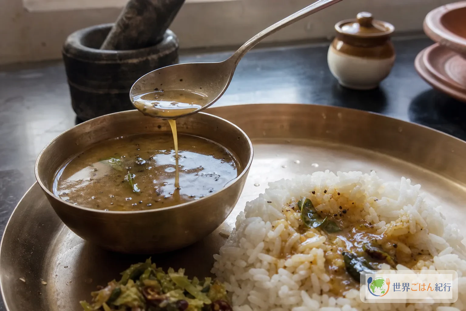 小さな器のラッサムを白いご飯に少量ずつかける食べ方