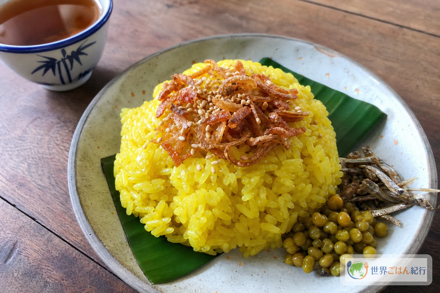 揚げ玉ねぎとごまをのせた黄色いもち米のミャンマー料理シータミン