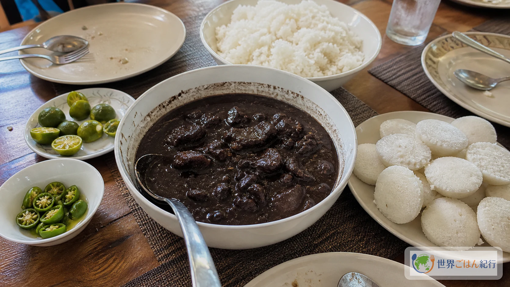 ディヌグアン、白ごはん、プト、ライム、青唐辛子を並べたフィリピン家庭の食卓