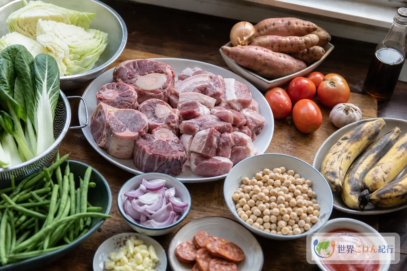 ポチェロの材料。肉、チョリソ、ガルバンゾ、サババナナ、野菜、トマトソースを台所に並べた様子