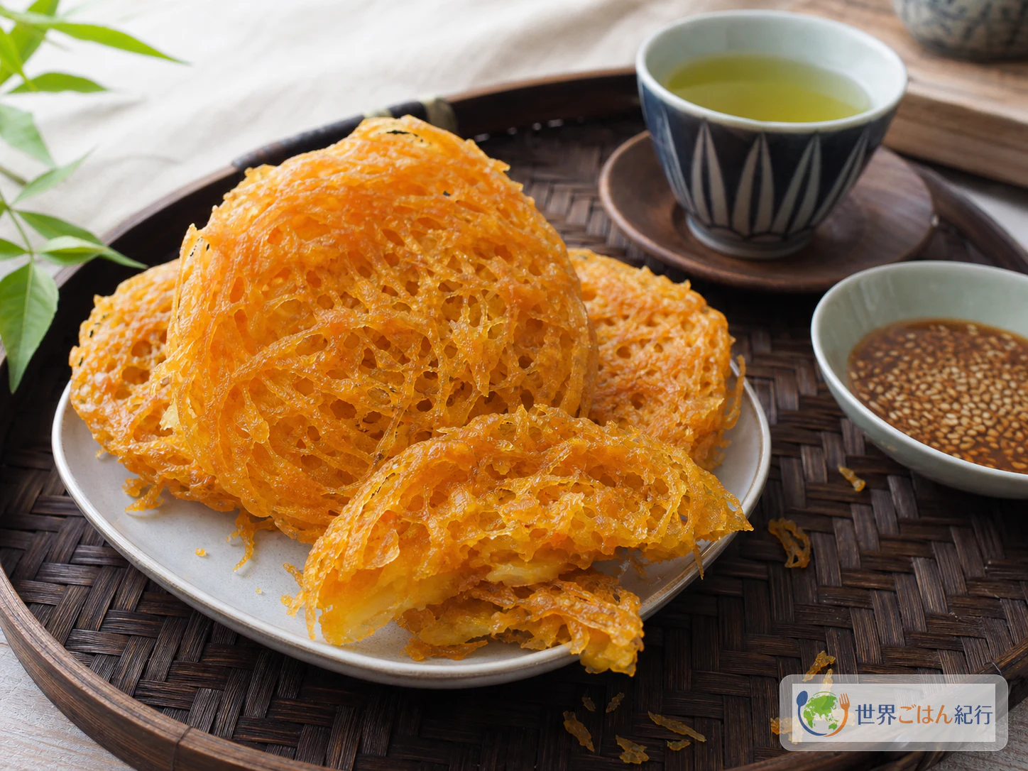 茶と一緒に皿へ盛ったバインレー。薄い網目の揚げ菓子を少し重ねて盛り、食卓に出している